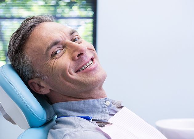 Senior man in dental chair smiling