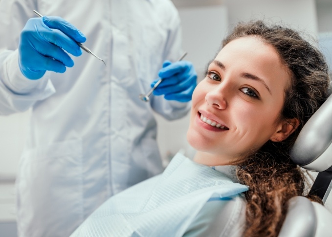 Smiling woman leaning back in dental chair