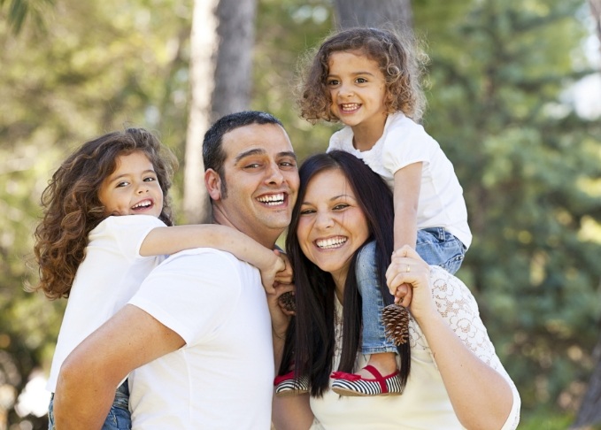 Family of four smiling outdoors