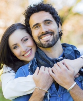 Young man and woman holding each other outdoors