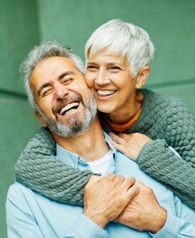 Smiling woman holding man from behind