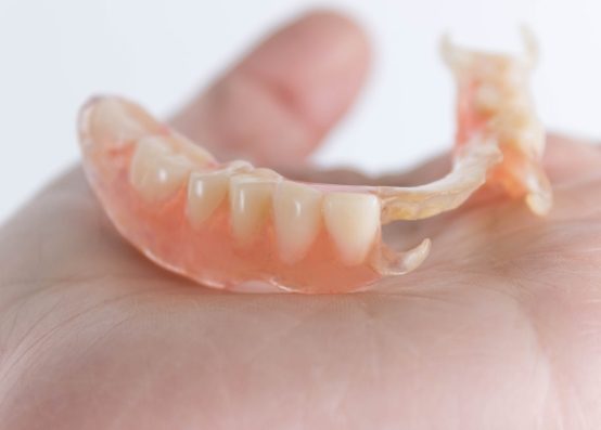 Hand holding a partial denture