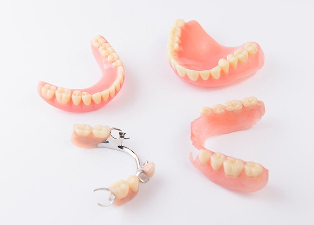 full and partial dentures against a white backdrop