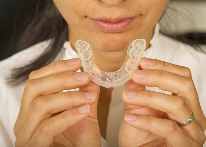 Woman holding an Invisalign aligner