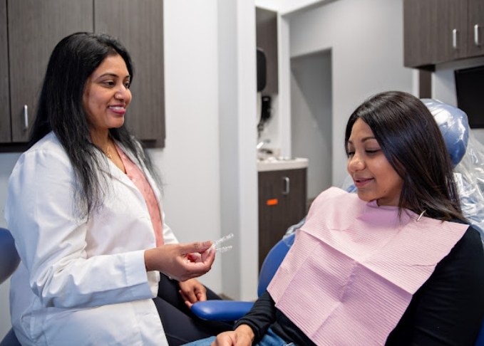 Doctor Buchupally showing a clear aligner to a dental patient