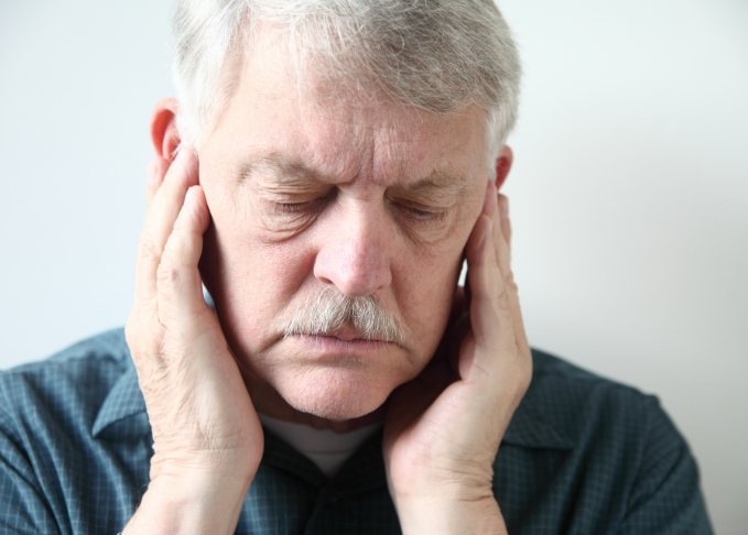 Man holding his temples in pain