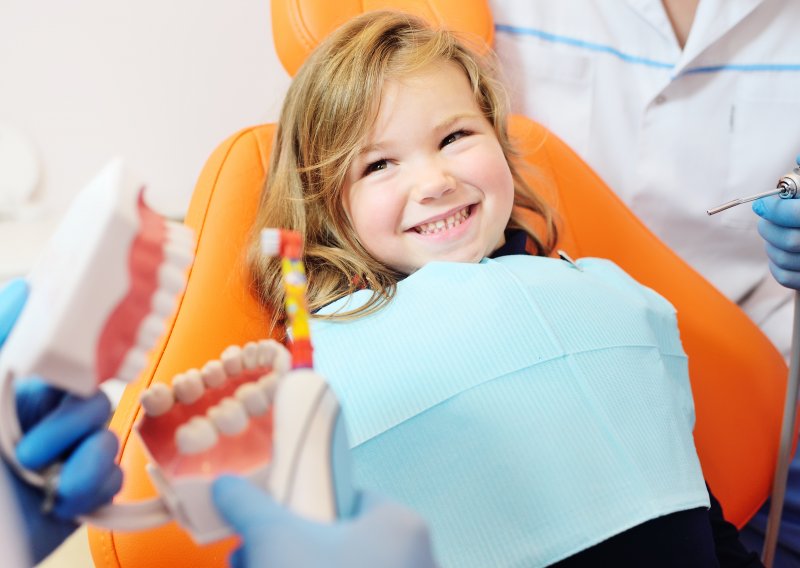 A smiling little girl who’s about to receive dental care